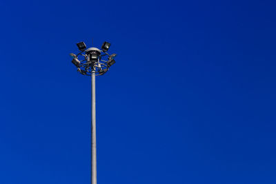 Low angle view of floodlight against clear blue sky