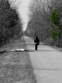 Rear view of woman walking on footpath