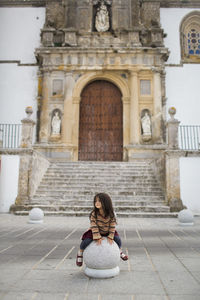 Rear view of woman sitting on steps