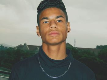 Portrait of young man standing against sky