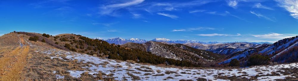 Scenic view of snowcapped mountains against blue sky