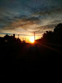 Silhouette of electricity pylons at sunset