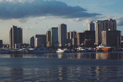 Sea by cityscape against sky