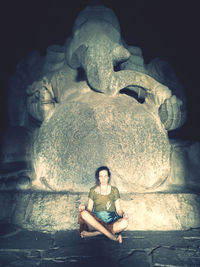 Portrait of young woman sitting on rock