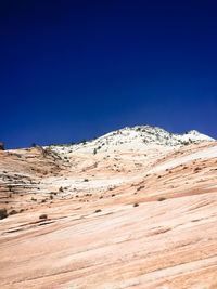 Scenic view of snowcapped mountains against clear blue sky