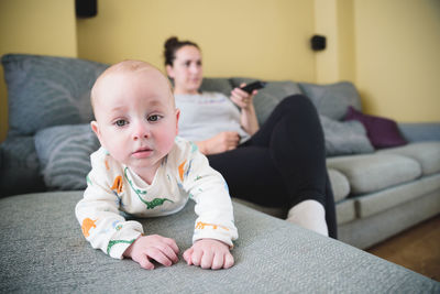 Portrait of cute boy sitting on sofa at home