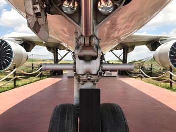 Close-up of airplane on runway against sky