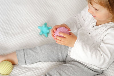 Baby girl playing tactile knobby balls. young child hand plays sensory massage ball