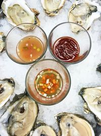 Directly above view of drinking glasses and oysters on ice