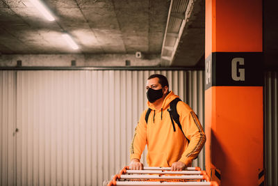 Full length of woman standing against orange wall