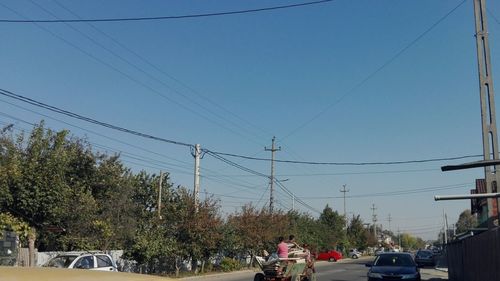 Cars on road against sky in city