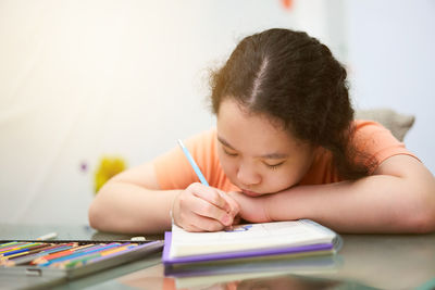 Close-up of girl studying at home