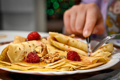 Close-up of hand holding ice cream in plate