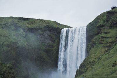 Scenic view of waterfall against sky