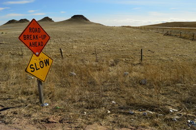 Road signs on field against sky