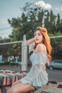 Beautiful young woman sitting outdoors