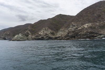 Scenic view of sea and mountains against sky