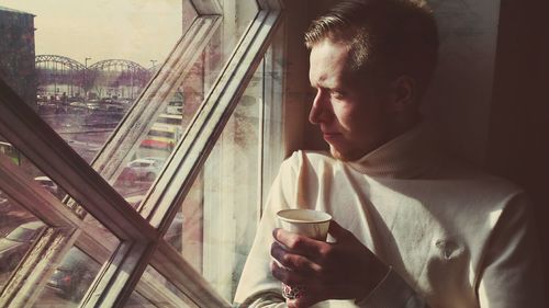 Close-up of man looking through window