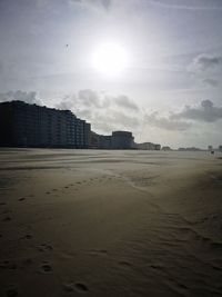 Scenic view of beach by buildings against sky
