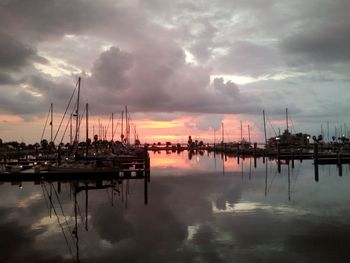 Sailboats in sea against cloudy sky