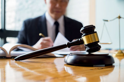 Midsection of man holding coffee cup on table