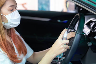 Portrait of woman holding camera in car