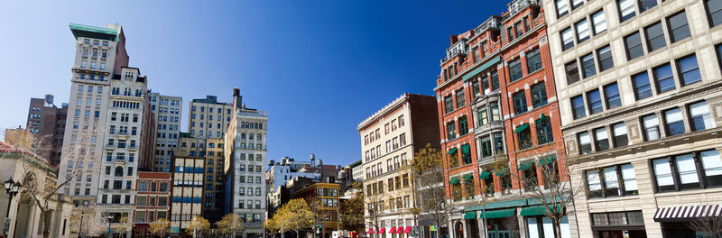 Low angle view of buildings against clear blue sky