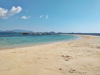 Scenic view of beach against blue sky