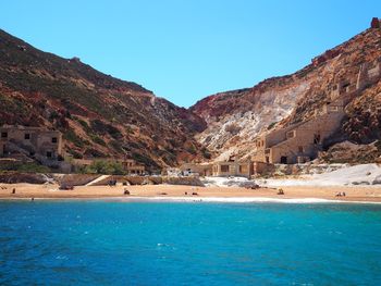 Scenic view of sea and mountains against clear blue sky