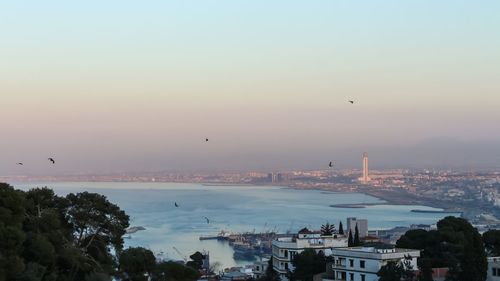 View of city buildings against sky during sunset