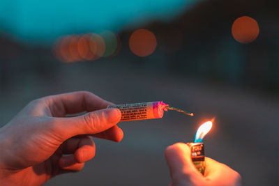 Close-up of hand holding lit candles