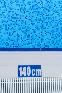 Close-up of text on wall by swimming pool