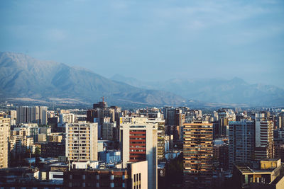 Buildings in city against cloudy sky