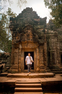 Full length of man standing outside temple against building