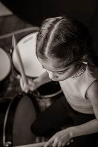 High angle of girl playing musical instrument indoors