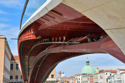 Low angle view of bridge and buildings against sky in city