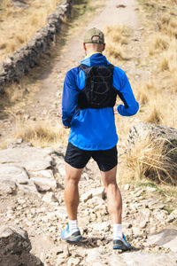 Rear view of man walking on field