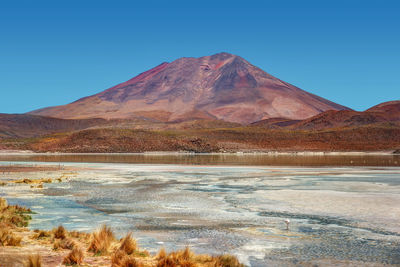 Scenic view of mountain range against blue sky