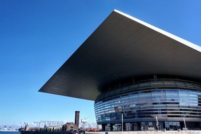 Low angle view of office building against blue sky