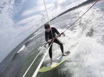 Fish-eye view of man kiteboarding on sea at beach