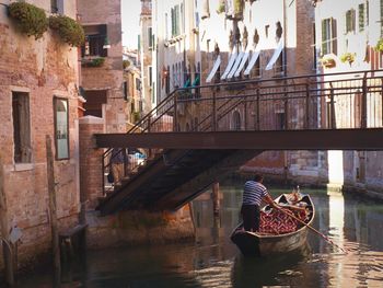 People in boat on canal in city