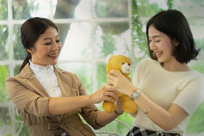 Portrait of a smiling young woman holding toy