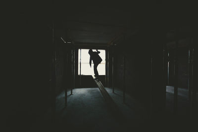 Silhouette man walking in corridor