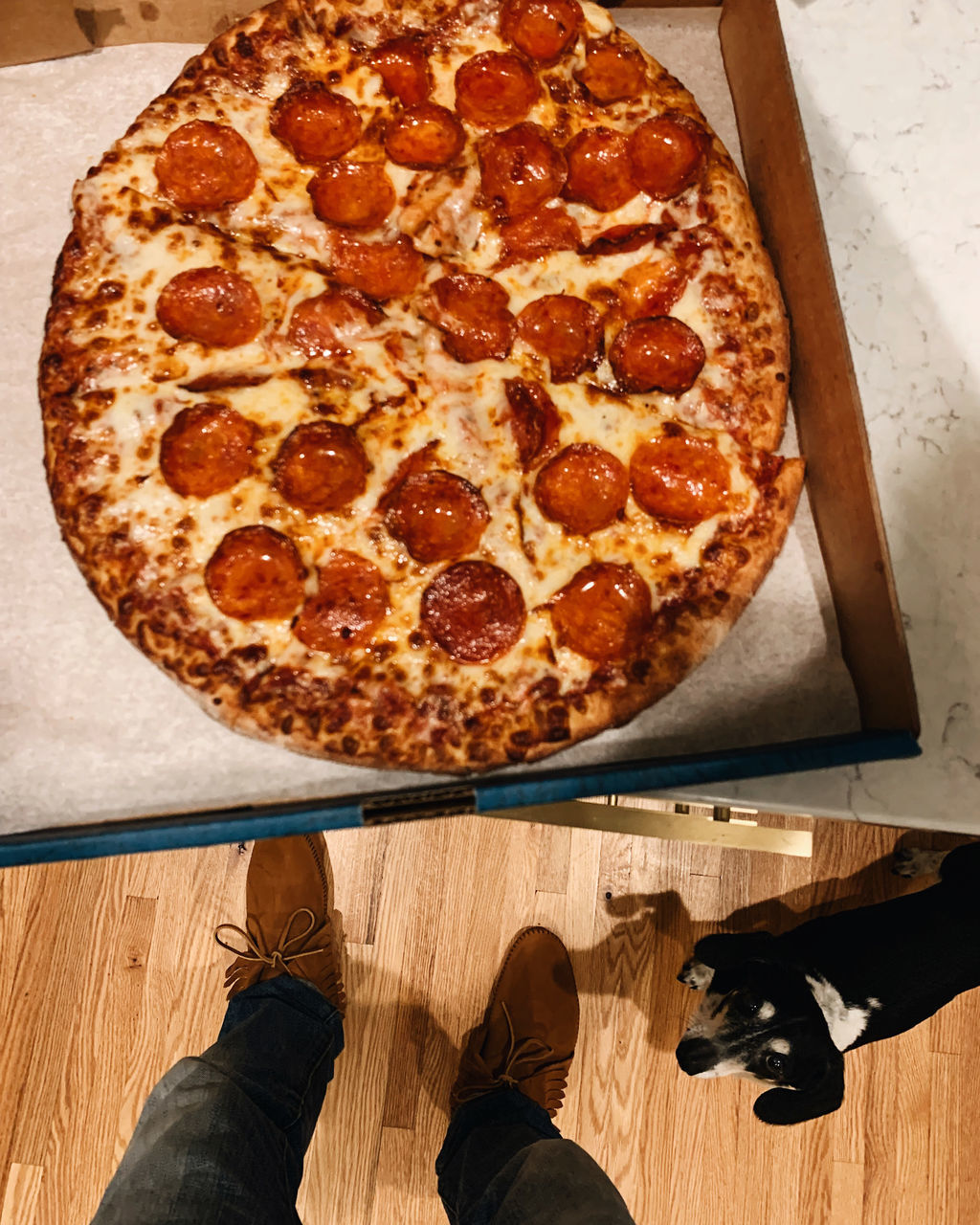pizza, food and drink, food, dish, high angle view, one person, personal perspective, low section, italian food, indoors, freshness, fast food, unhealthy eating, cuisine, cheese, directly above, pepperoni pizza, pepperoni, human leg, dairy, wood, pizza box, shoe, sausage, slice, men, lifestyles, baked