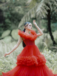 Low angle view of young woman standing on field