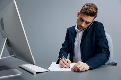 Young man using laptop while sitting in office