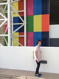 Full length side view portrait of woman standing on sidewalk