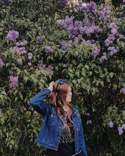 Woman standing by purple flowering plants