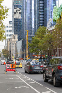 Cars on city street by buildings