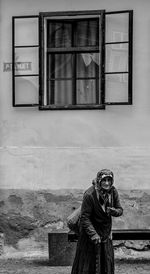 Man photographing window on building